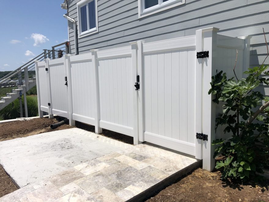 1 solid white vinyl privacy fence and gates used for ultility enclosure on residential home