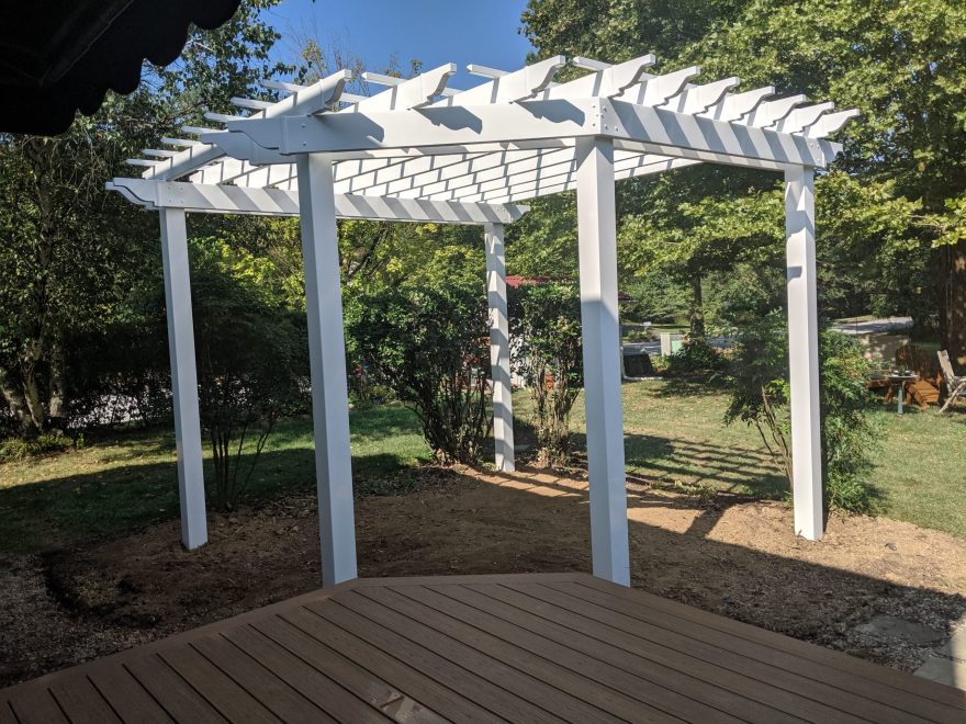 Free Standing White Vinyl Pergola sitting next to a Trex Transcend Havana Gold Deck