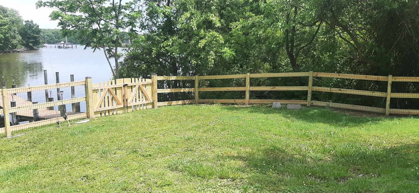 Pressure treated 3-rail ranch rail fence with black mesh and double arched gate-min