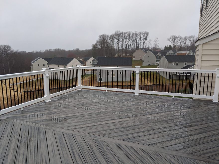 Trex Transcend Island Mist deck boards in a Herringbone layout with White Washington Vinyl Railing and Black Round Aluminum Balusters in Eldersburg, MD