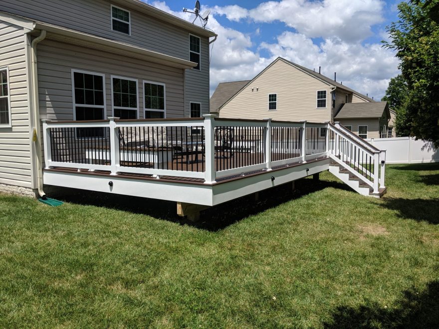 Trex Transcend Spiced Rum Deck Boards with White Lincoln Vinyl Railing, Black Round Aluminum Balusters and matching cocktail rail