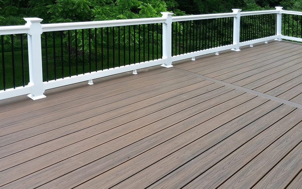 Trex Transcends Spiced Rum Composite Deck with white vinyl railing and black aluminum balusters