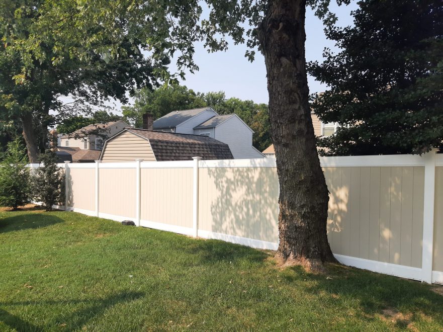 Two toned tan and white vinyl privacy fence